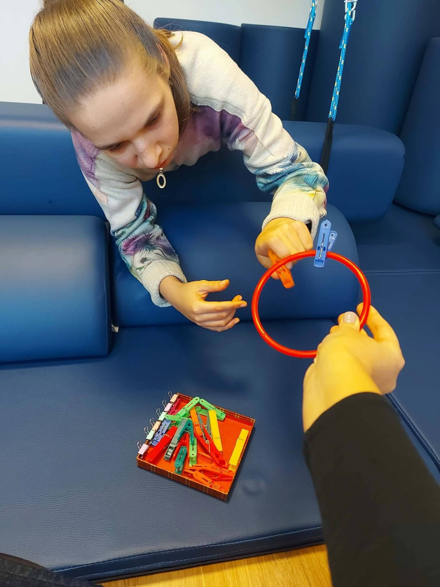 Practising fine motor skills with a ring and clothes pegs