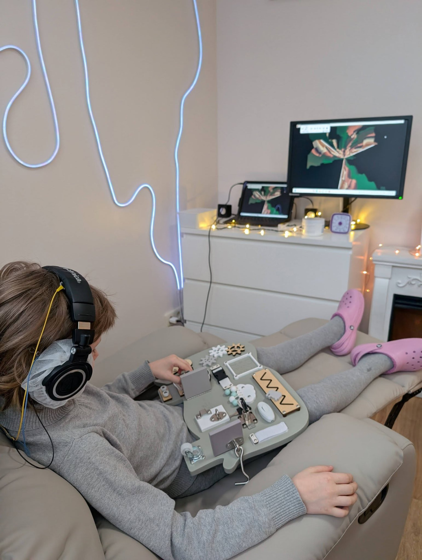 A calm sensory room with headphones and a busy board
